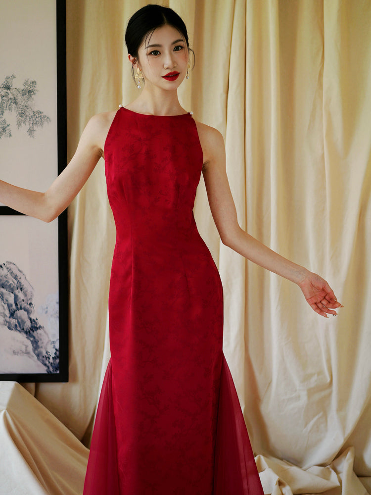 Bride in red cheongsam dress holding fan, styled for traditional engagement or wedding ceremonies.