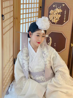 White Yanji Hanbok court dress with floral embroidery and traditional accessories, ideal for Korean cultural or ceremonial fashion.
