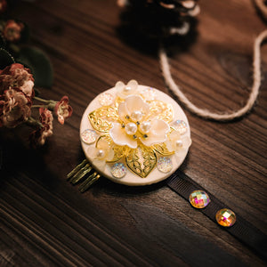 White Korean traditional headgear with gold floral motif and pearl accents, ideal for ethnic hair styling.