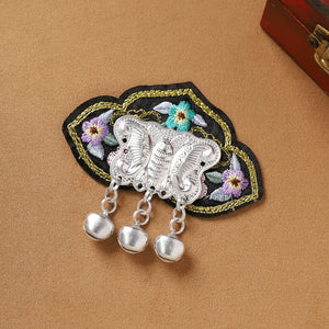 Ethnic Guizhou Miao fridge magnet with black floral embroidery and silver butterfly design with bell-shaped fringe, handmade and unique.