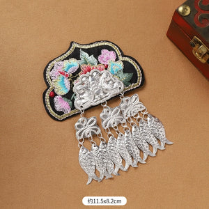 Detailed Guizhou Miao fridge magnet with black floral embroidery and silver fish fringe, measuring 11.5x8.2cm, handmade ethnic decor.
