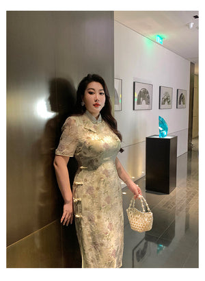 Modern green plus size qipao dress with sheer sleeves and floral texture, styled with pearl handbag for a sophisticated Chinese look.