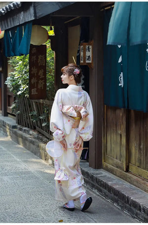 Rear view of a Japanese kimono dress for women, showcasing an elegant obi bow. A classic yukata design with floral accents.