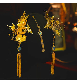 Gold Chinese dragonfly hairpin set with blue gemstone and floral fringe, displayed on black mannequin for engagement wear.