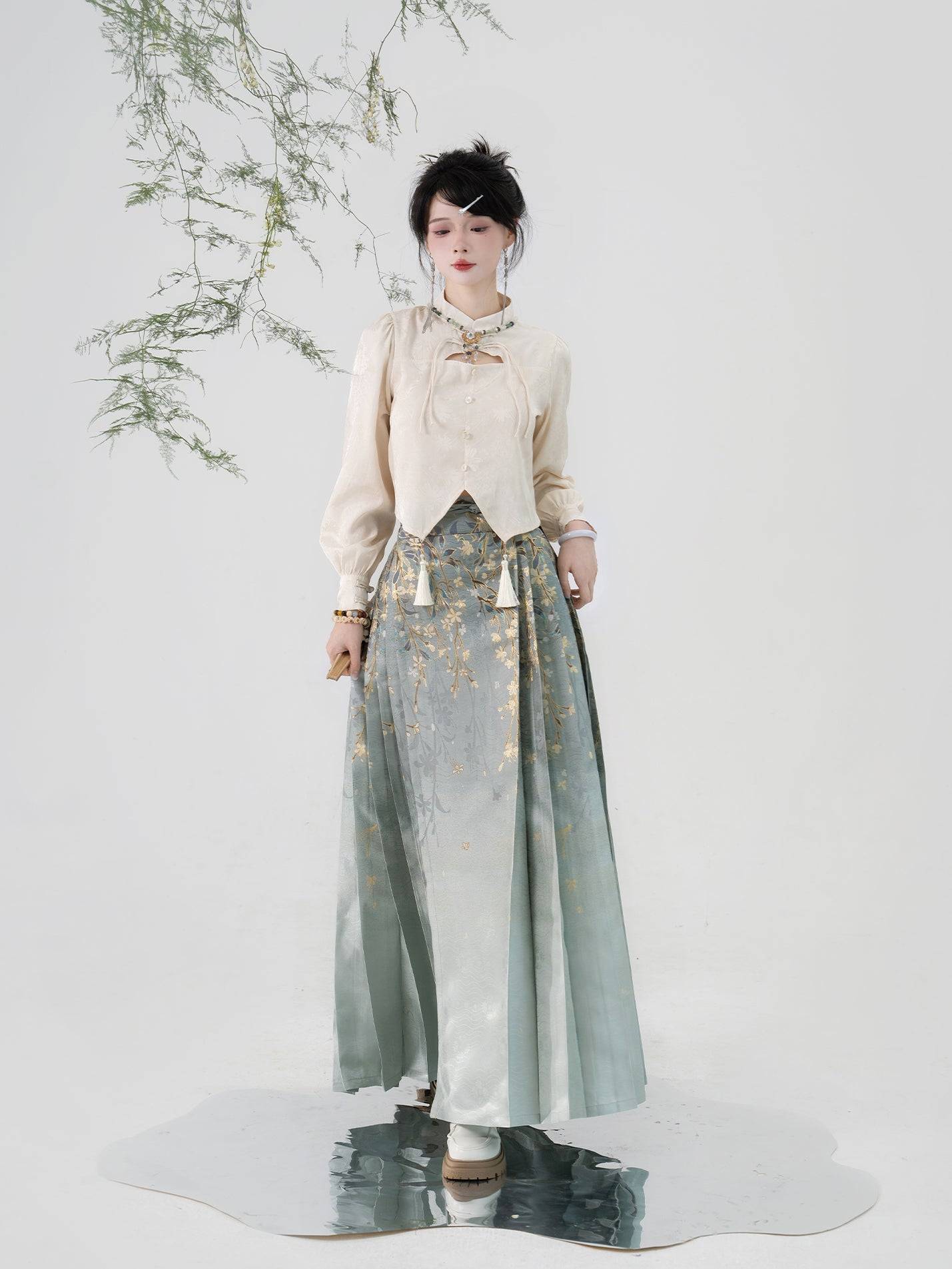 Elegant imitation Ming-dynasty Hanfu skirt for women, adorned with jasmine flower patterns and shimmering gold thread on soft green fabric.