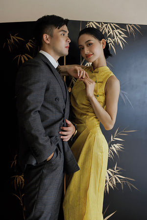 Wedding couple featuring bride in yellow Cheongsam with dark pattern, ideal for cultural bridal fashion.