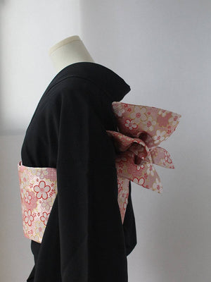Side view of pink floral kimono brocade waist seal with bow, styled on black kimono. 120cm reversible cotton canvas design.