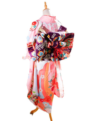 Back view of pink floral kimono with purple big three-leaf shaped bow belt. Swinging sleeves and geisha-style belt bag complete the look.