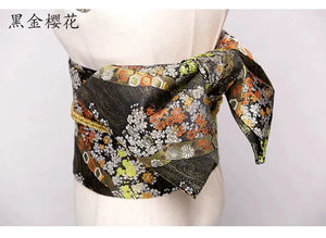 Yukata bow belt with intricate brocade design in black, gold, and floral patterns. This kimono waist seal adds elegance with its stylish knot.