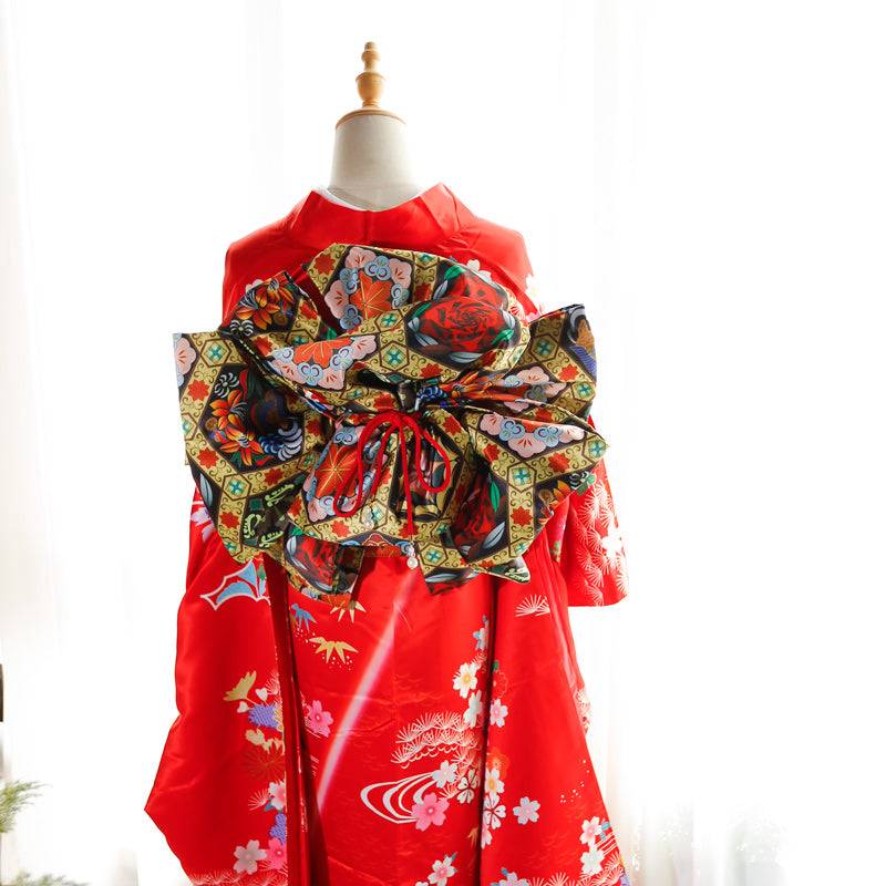 Front view of red kimono with black and green floral big three-leaf bow belt. Swinging sleeves and geisha-inspired belt bag included.