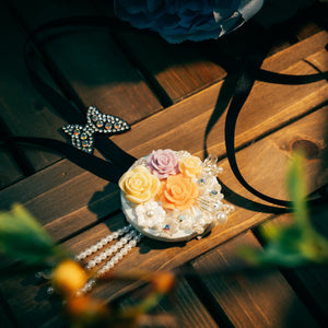 Colorful Korean traditional headgear with yellow, purple, and pink roses, pearl tassels, and butterfly charm, suitable for hanbok outfits.