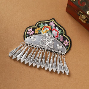 Black floral Guizhou Miao fridge magnet with silver arrowhead fringe, handmade ethnic kitchen ornament with cultural charm.