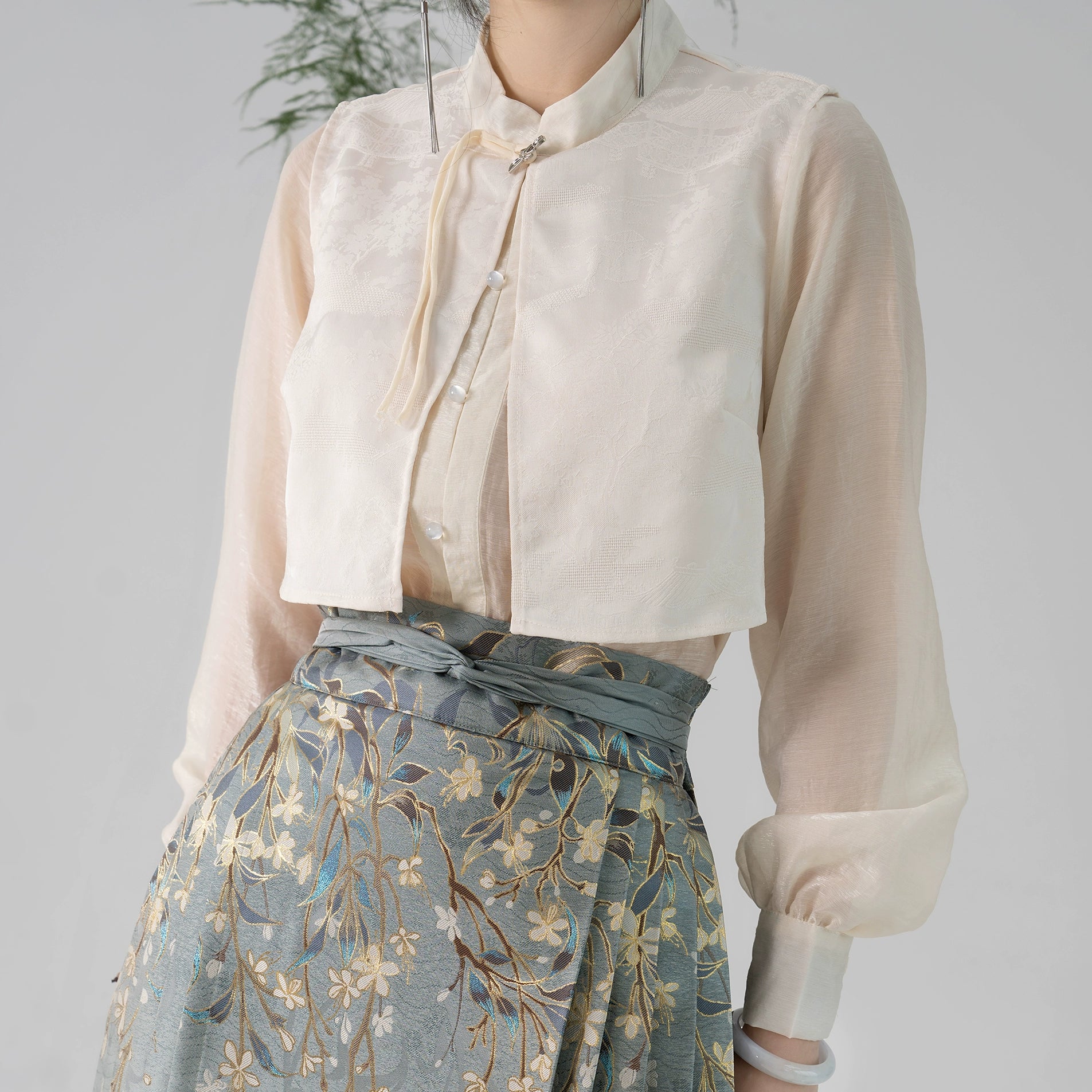 Detailed view of cream blouse and high-waisted Hanfu skirt with gold jasmine embroidery, perfect for traditional wear.