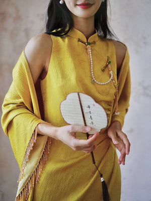 Close-up of yellow Cheongsam bridal dress with fan, highlighting intricate details and cultural elegance.