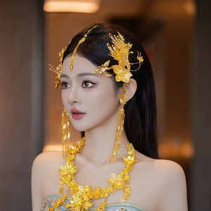 Elegant gold dragonfly hairpin with intricate floral design and fringe, styled for traditional Chinese bridal wear.