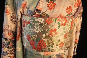 Back view of Brocade Premium Styling Bow Waist Seal on floral kimono, showcasing wide brocade belt with colorful floral patterns.