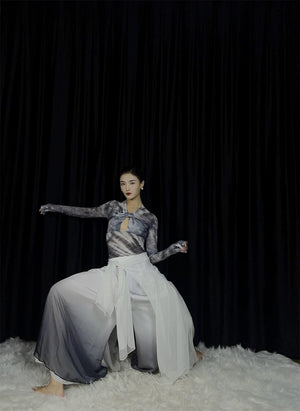 Model wearing watercolor skirt & matching top, sitting pose, black curtain