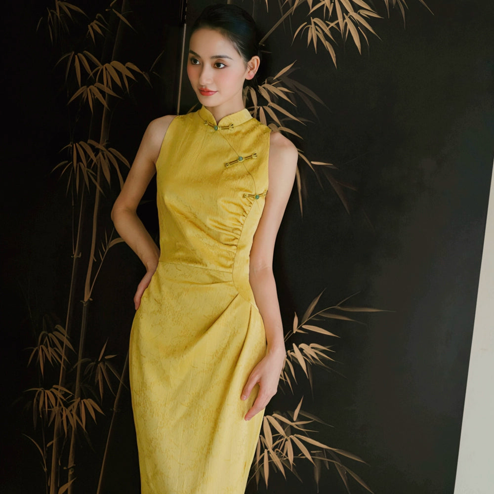 Close-up of yellow Cheongsam bridal dress with fan, highlighting fitted silhouette and cultural charm.