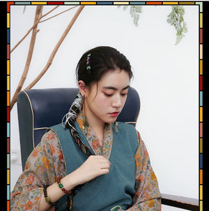 Tibetan-inspired cross-collared top with floral sleeves and braids
