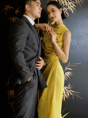 Couple in wedding attire featuring the bride in a yellow Cheongsam dress with dark pattern, ideal for traditional ceremonies.