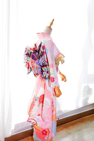 Side view of pink floral kimono with purple big three-leaf bow belt. Swinging sleeves and geisha-style belt bag add elegance.