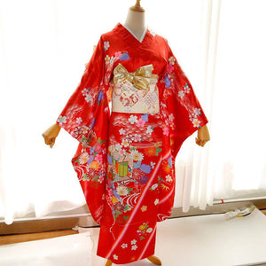 Front view of red kimono with gold and cream big three-leaf bow belt. Swinging sleeves and geisha-style belt enhance traditional look.