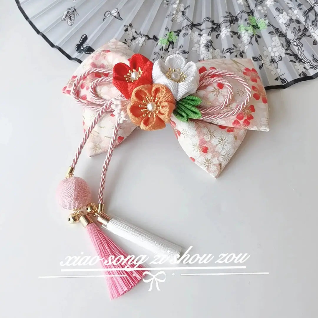 Cream cherry blossom hairpin with orange and white flowers and pink tassels, ideal for Japanese lolita or kimono outfits.