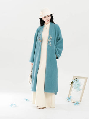 Teal coat and ivory dress full-length front view