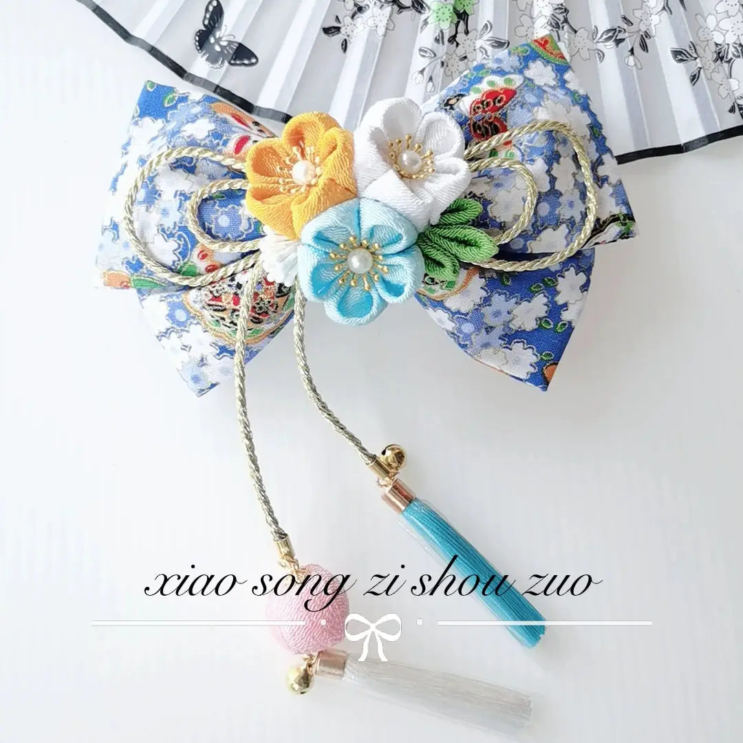 Blue floral Japanese kimono hair clip with yellow, white, and turquoise cherry blossoms and teal tassels.