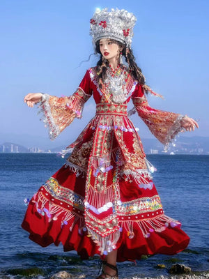 Flowing red Miao wedding dress with embroidery and pearl accents, styled with traditional silver headwear for cultural performances.