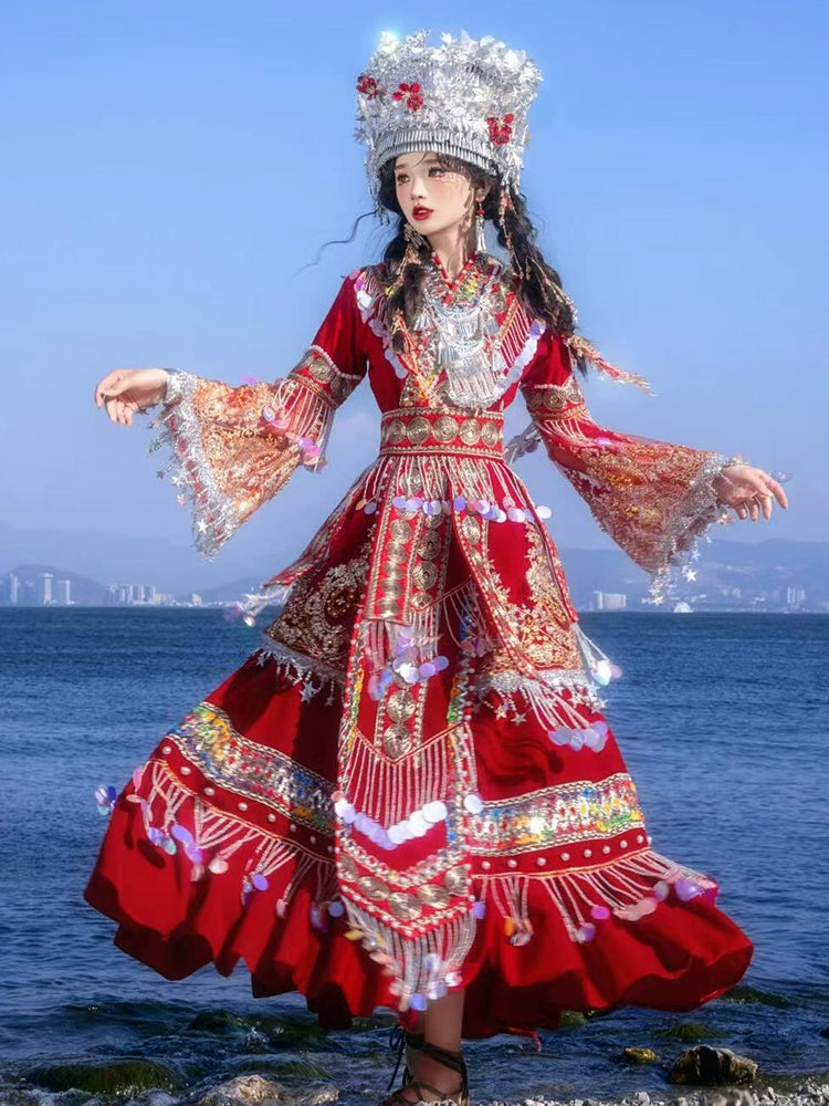 Flowing red Miao wedding dress with embroidery and pearl accents, styled with traditional silver headwear for cultural performances.