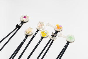 Assorted Korean traditional headgear accessories with floral and pearl designs on black ribbons, ideal for hanbok and cultural events.