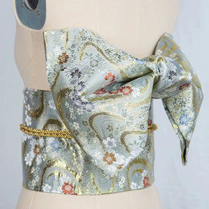 Light blue and gold floral brocade bow belt styled on mannequin, ideal for traditional Japanese yukata waist styling and photo shoots.