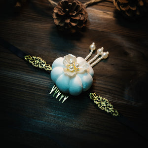 White Hanbok headdress with floral pearl design and gold accents, representing Yanji Folk Korean tradition on dark wood.