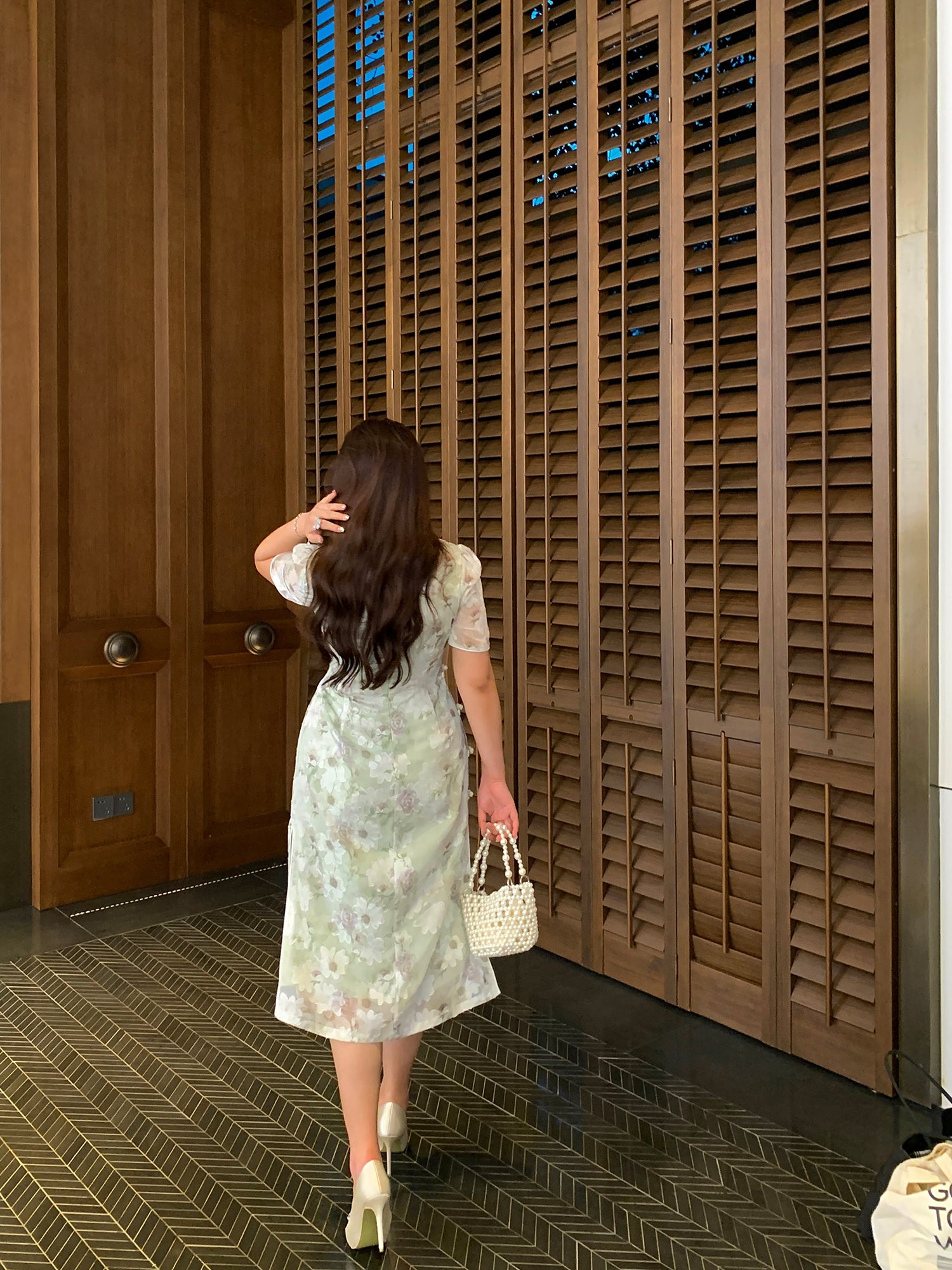 Back view of modern green plus size qipao dress with subtle floral pattern, showcasing elegant silhouette and soft fabric flow.