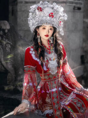 High-end red Miao wedding dress featuring ornate embroidery, pearls, and silver accessories, perfect for ceremonial or stage use.