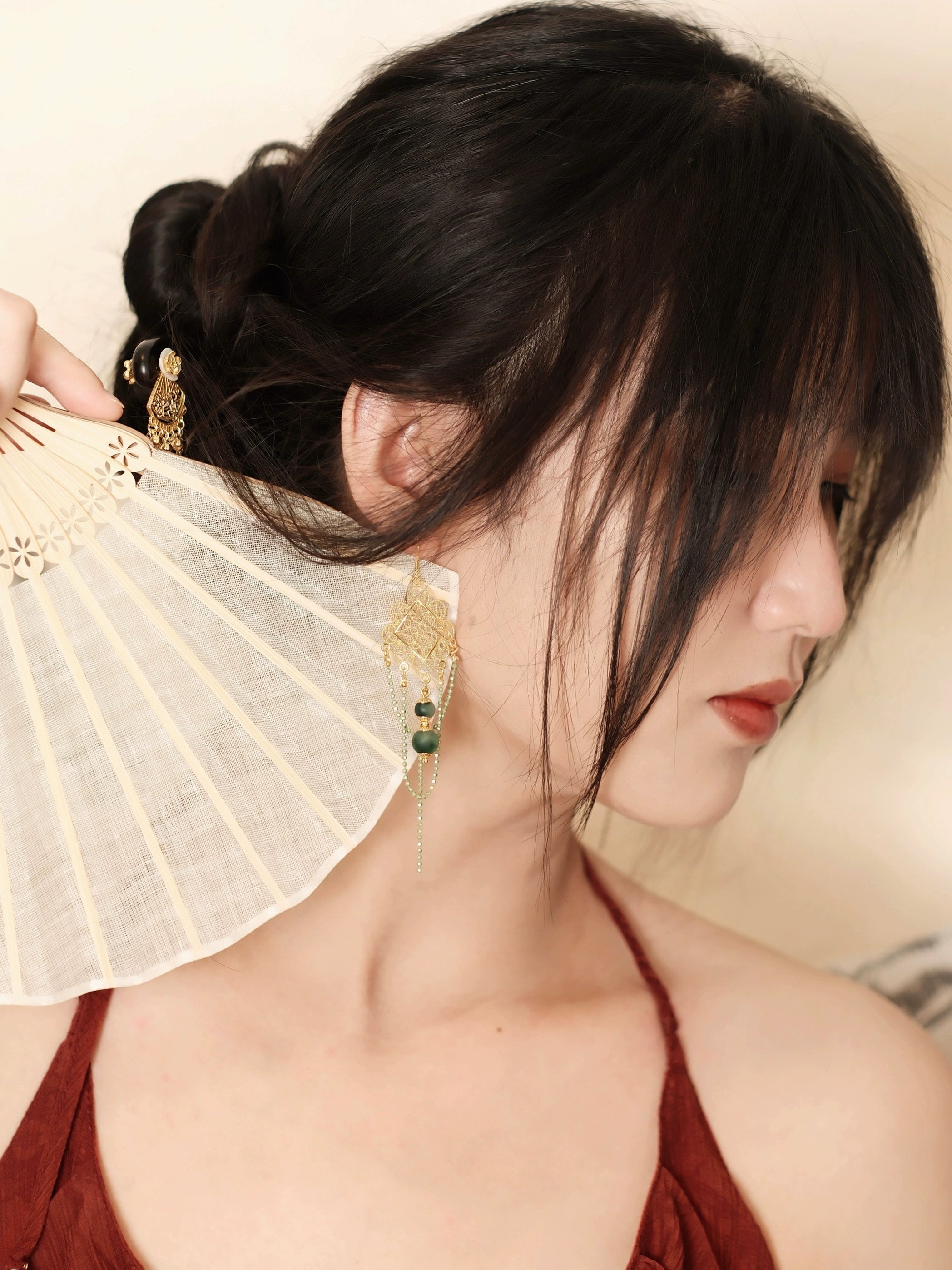 Su Mask Ear Clips - Hanfu Gold Tassel Earrings with intricate floral filigree and green beads, styled with fan and traditional red outfit.