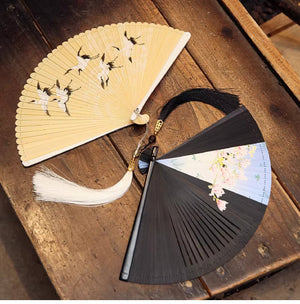 Cream and black bamboo folding fans with crane and cherry blossom designs. Includes white and black tassels for Hanfu dance.
