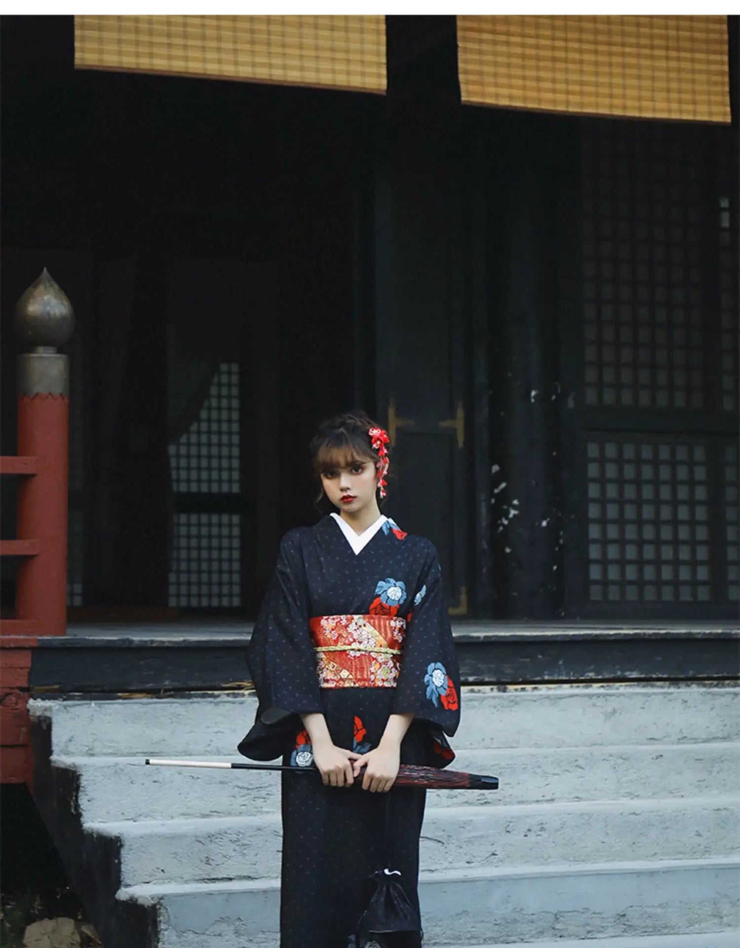 Black Japanese yukata with red and blue floral patterns, styled with a red obi belt and traditional sword. A literary and festive outfit.