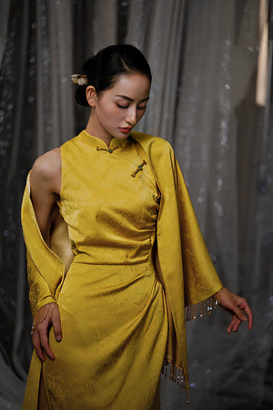 Close-up of yellow Cheongsam with shawl, showcasing dark jacquard pattern and bridal elegance.