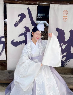 White Yanji Hanbok court dress with wide sleeves and floral embroidery, traditional Korean attire for formal or daily wear.