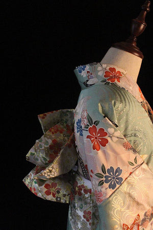 Side view of Brocade Premium Styling Bow Waist Seal on floral kimono, showing layered bow design and shimmering brocade fabric.