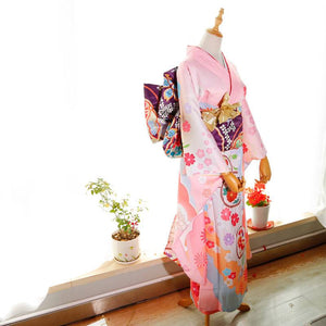 Front view of pink floral kimono with purple big three-leaf bow belt. Swinging sleeves and geisha-style belt bag included.