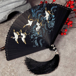 Black folding fan with crane and wave design, ideal for Hanfu dance. Full bamboo structure with black tassel for traditional Chinese style.