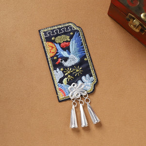 Blue bird embroidered Guizhou Miao fridge magnet with silver cone fringe, handmade ethnic kitchen accessory.
