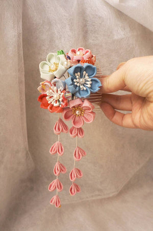 Close-up of Japanese crepe kimono hair comb with detailed flowers and long pink tassels, perfect for cultural or cosplay styling.