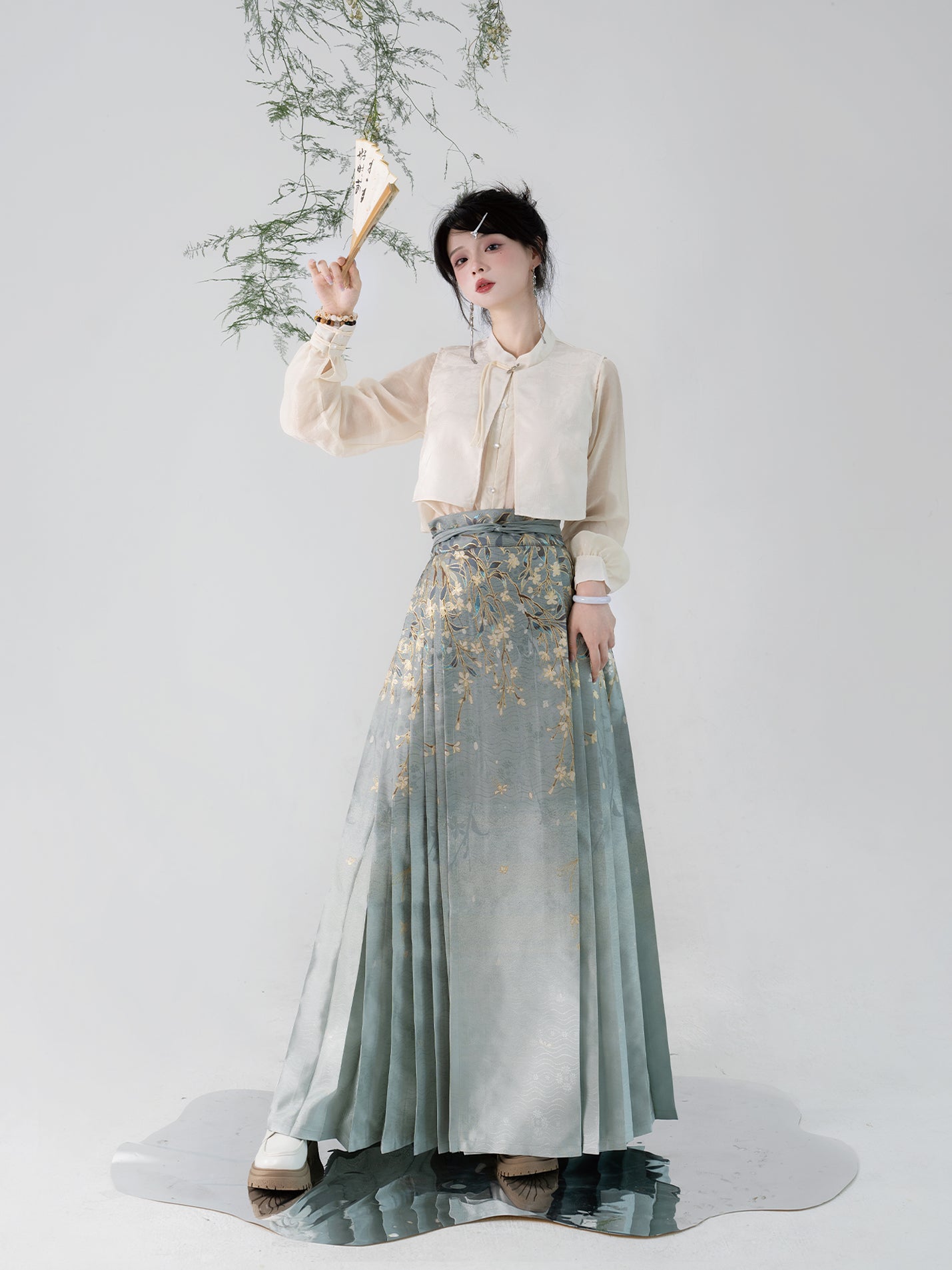 Traditional Hanfu horse skirt with gold floral embroidery, inspired by Ming-dynasty fashion, styled with a sheer cream blouse.