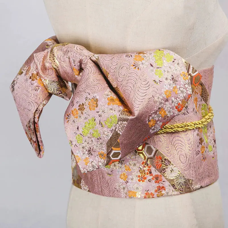Elegant pink brocade Yukata bow belt with floral patterns and gold accents. A stylish kimono waist seal for traditional Japanese attire.