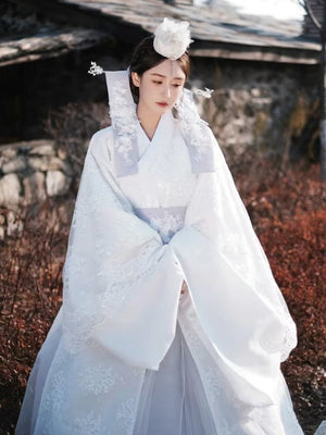 White Yanji Hanbok court dress with floral embroidery, traditional Korean national costume for daily wear, styled with a white headpiece.