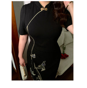 Close-up of black plus size cheongsam dress with gold embroidery and mandarin collar, highlighting detailed craftsmanship.